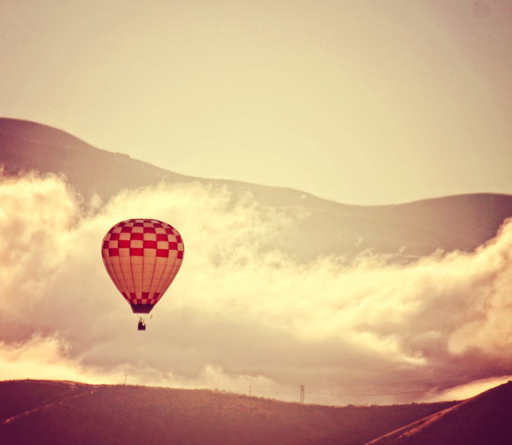image showing hot air balloon in the distance against mountain skyline